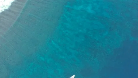 Frame from the drone vertically down onto the turquoise blue ocean along which a 库存影片 130766564