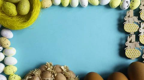 Frame with Easter eggs and copy space for text on blue background. Stock Photos