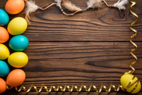 Frame from easter eggs, gold ribbon and feathers Stock Photos