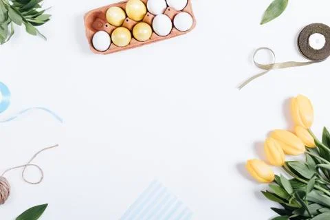 Frame of Easter eggs, yellow flowers, boxes of gifts and ribbons Stock Photos