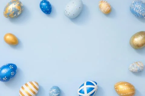 Frame of Easter golden decorated eggs on blue background. Minimal easter concept Stock Photos