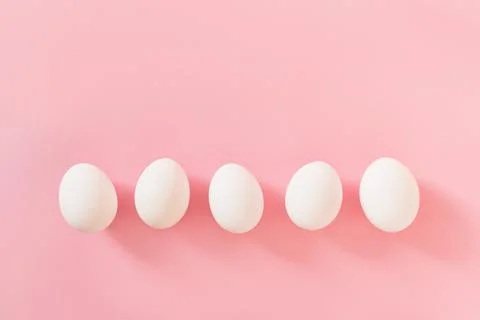 Frame of Easter white natural eggs set isolated on pastel pink background Stock Photos