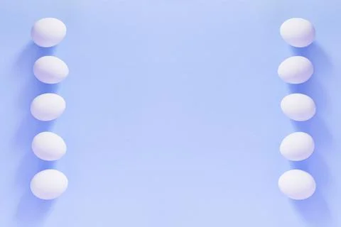 Frame of Easter white natural eggs set isolated on pastel blue background Stock Photos