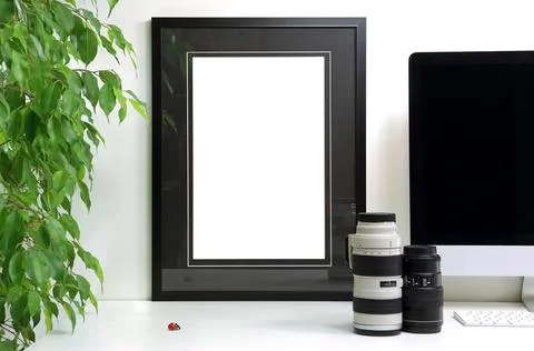 Frame with empty black outlines to customize placed on a modern desk and lenses 스톡 사진