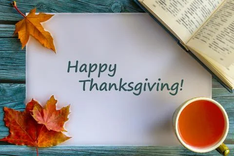 Frame with fall maple leaves, cup of tea and book. Inscription on white backg Stock Photos