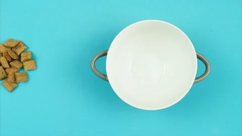 Frame-by-frame animation of a cookie of chocolate pads filling a bowl. Video stock 136849195