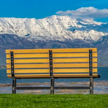 Frame Frame Square Back view of an empty bench overlooking a calm lake on a Stock Photos