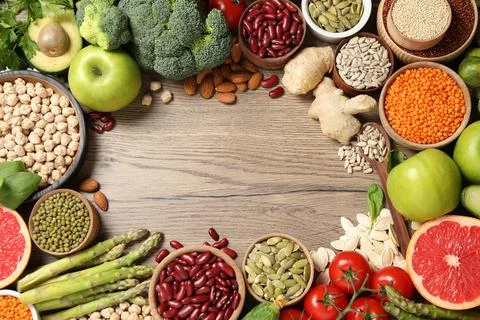 Frame of fresh vegetables, fruits and seeds on wooden table, flat lay. Space  Stock Photos