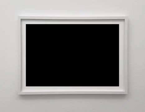 Frame hangs alone on wall. Thin rectangle with wooden mount offers minimalist Stock Photos
