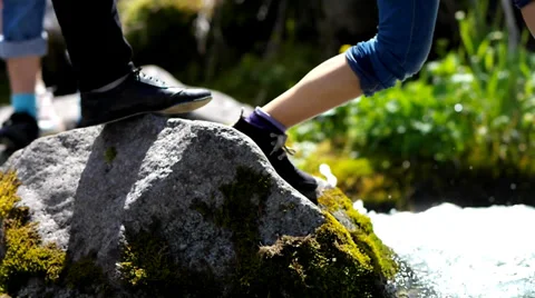 In the frame of the human foot, jumping through a mountain stream. Stock Footage 39116215