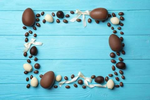 Frame made of chocolate Easter eggs on color wooden background, top view with Stock Photos