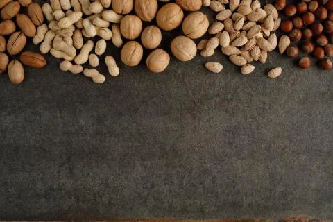 Frame made of different types of nuts on stone background Stock Photos