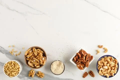 Frame made of different types of nuts in bowls Stock Photos