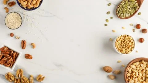 Frame made of different types of nuts in bowls Stock Photos