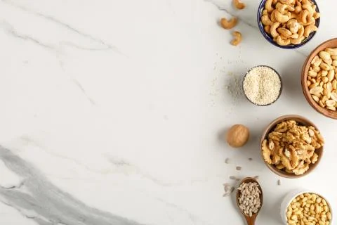 Frame made of different types of nuts in bowls Stock Photos