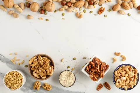 Frame made of different types of nuts in bowls Stock Photos