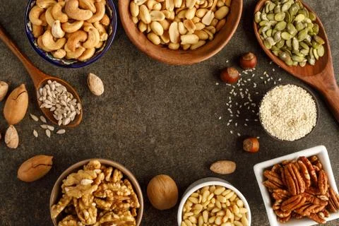 Frame made of different types of nuts in bowls Stock Photos