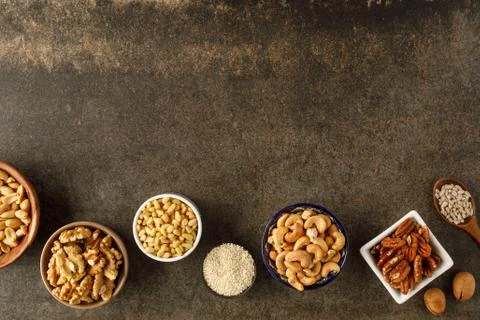 Frame made of different types of nuts in bowls Stock Photos