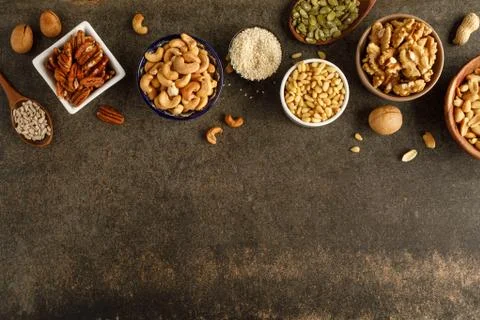 Frame made of different types of nuts in bowls Stock Photos