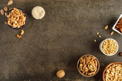 Frame made of different types of nuts in bowls Stock Photos