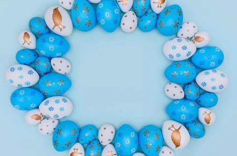 Frame made of Easter eggs on blue background. Stock Photos