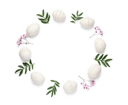 Frame made of Easter eggs decorated with pearls, leaves and flowers on white  Stock Photos