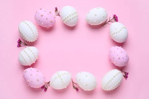 Frame made of Easter eggs decorated with pearls and flowers on pink backgroun Stock Photos