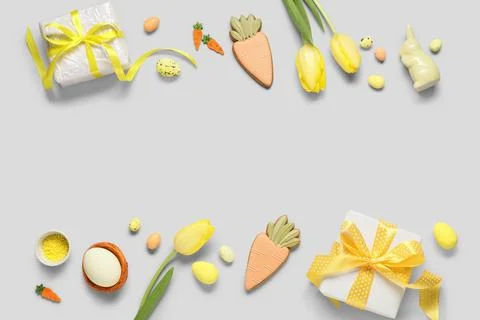 Frame made of gift boxes, Easter eggs, cookies in shape of carrot and tulip f Stock Photos