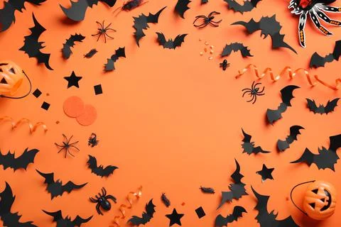 Frame made with Halloween decor elements on orange background, flat lay. Spac Stock Photos