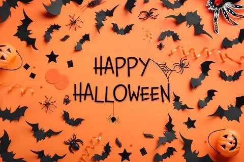 Frame made with Halloween decor elements on orange background, flat lay Stock Photos