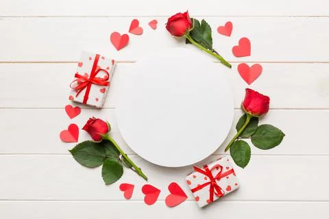 Frame made of rose, git box, heart and blank greeting card mockup on Colored  写真素材