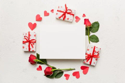 Frame made of rose, git box, heart and blank greeting card mockup on Colored  Foto stock