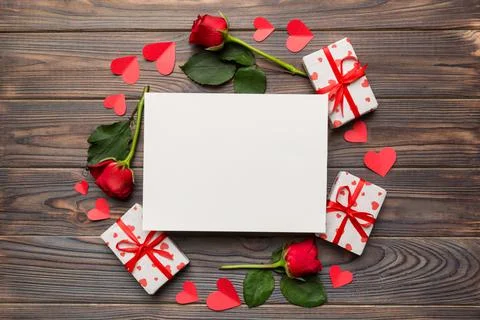 Frame made of rose, git box, heart and blank greeting card mockup on Colored  Fotos de archivo