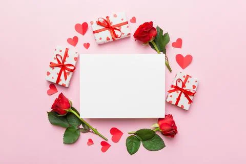 Frame made of rose, git box, heart and blank greeting card mockup on Colored  写真素材