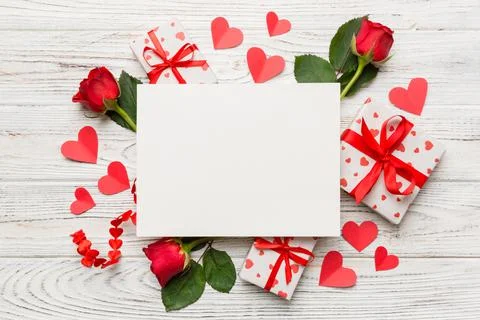 Frame made of rose, git box, heart and blank greeting card mockup on Colored  写真素材