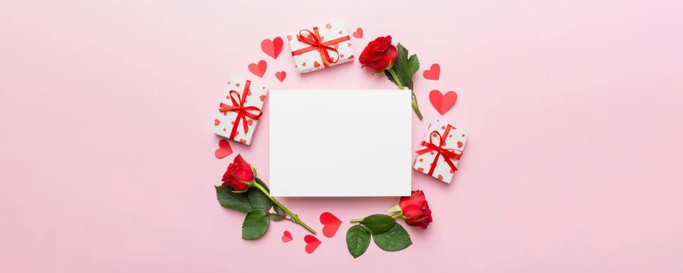 Frame made of rose, git box, heart and blank greeting card mockup on Colored  写真素材
