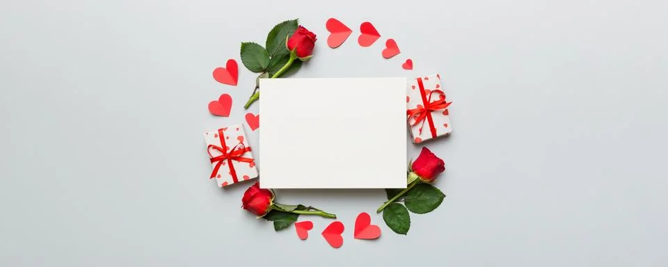 Frame made of rose, git box, heart and blank greeting card mockup on Colored  写真素材
