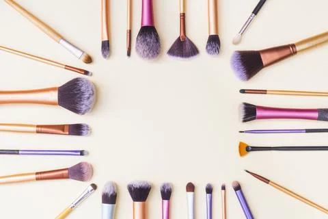Frame made with set makeup brushes beige background Stock Photos