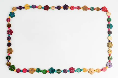 Frame of multi coloured beads hand made from coconut shell, flowers and circles Stock Photos