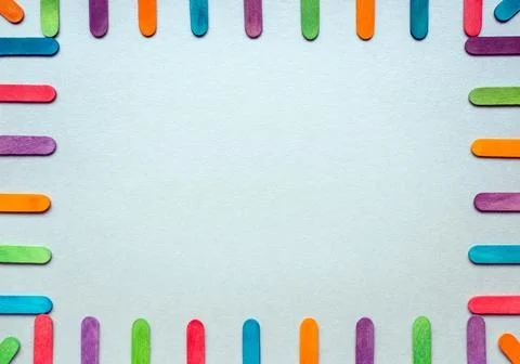 Frame with multicolored rounded flat sticks on a light gray background. Stock Photos