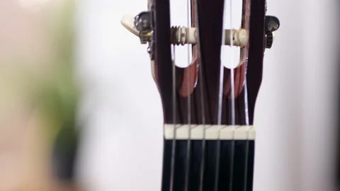 In the frame of the neck of an acoustic guitar, strings and frets. close up Video stock 140750366