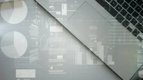 Frame one revealing soft data overlays scrolling across angled silver laptops, Stock Footage 334744249