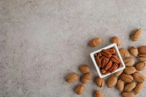 Frame of pecan nuts on marble background. Square bowl of nuts in the corner Stock Photos