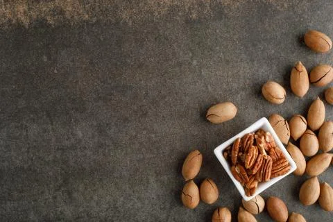 Frame of pecan nuts on marble background. Square bowl of nuts in the corner Stock Photos