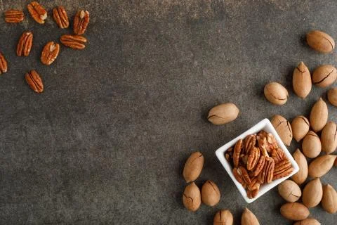 Frame of pecan nuts on marble background. Square bowl of nuts in the corner Stock Photos