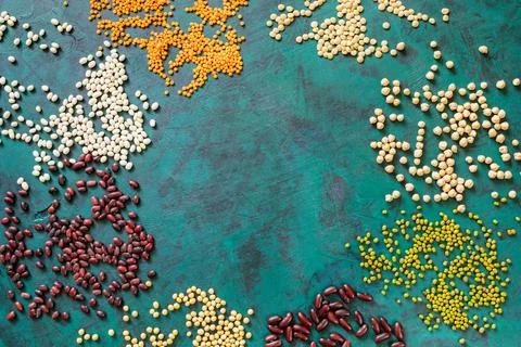 Frame of scattered beans on emerald background with copy space in middle. Foto stock