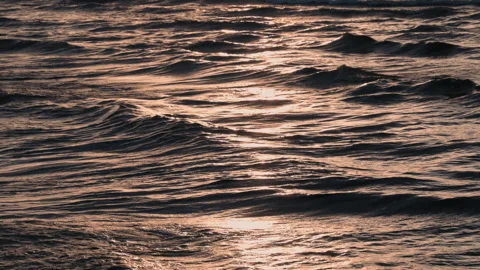 In the frame, sea waves shimmer in the rays of the setting sun. Water Stock Footage 243976253