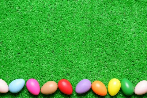 Frame from several multi colored easter eggs on green grass lawn background Foto stock