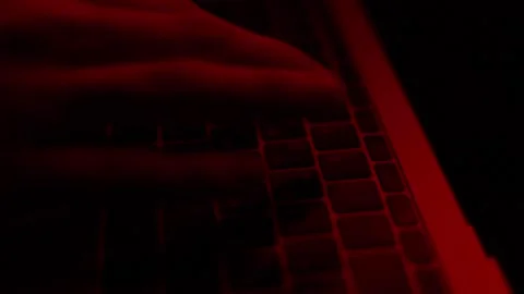 Frame side view hands typing text on keyboard under red light Stock Footage 229706382