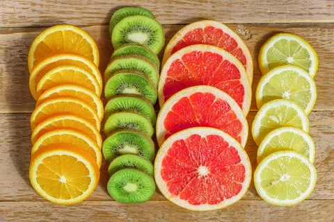 Frame with slice of oranges, lemons, kiwi, grapefruit pattern on wooden bac.. Stock Photos